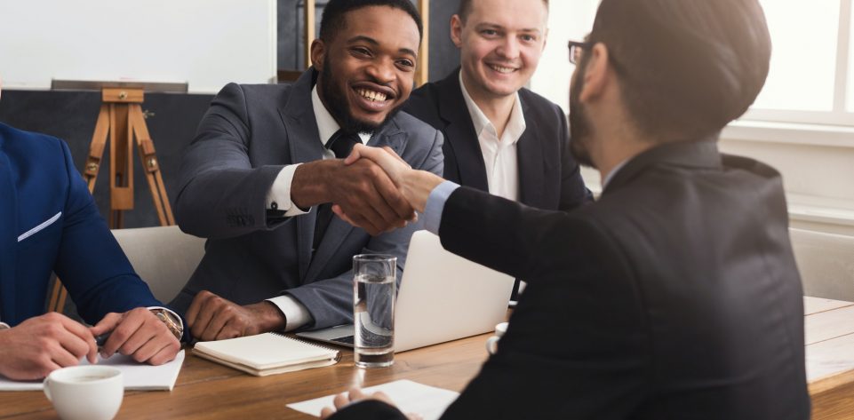 Business handshake at multiethnic office meeting